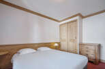 Discover the charm of this cozy bedroom, featuring a comfortable bed and ample storage.