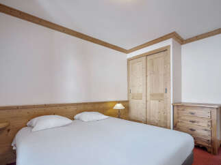 Discover the charm of this cozy bedroom, featuring a comfortable bed and ample storage.