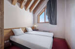 This cozy bedroom features two twin beds with crisp white linens, perfect for a comfortable stay.