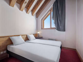 This cozy bedroom features two twin beds with crisp white linens, perfect for a comfortable stay.
