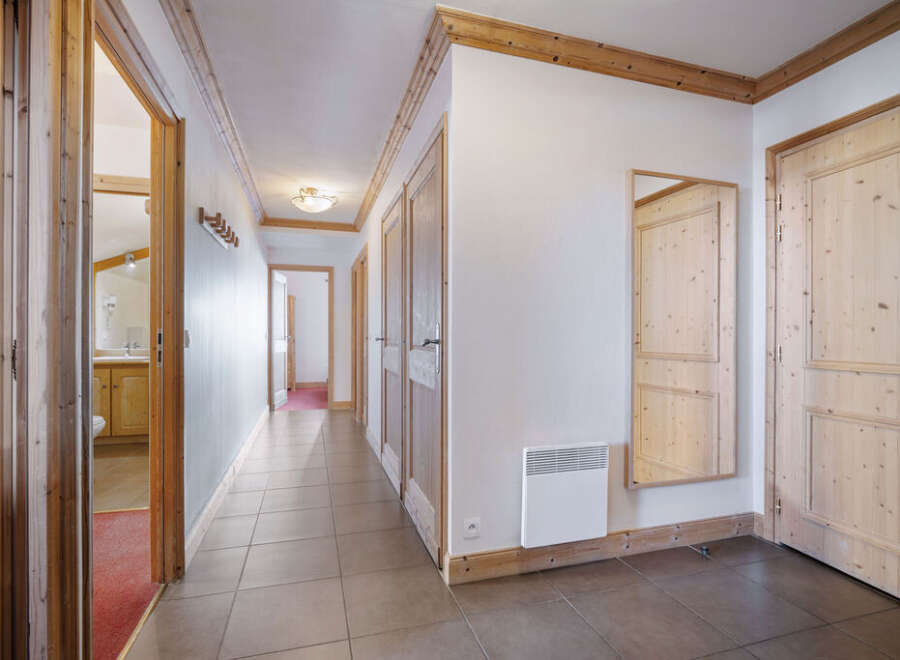 Step into this inviting hallway, showcasing a warm and rustic aesthetic with its wooden doors and trim.
