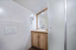This bathroom features a stylish wooden vanity with a sleek sink, offering ample storage and a touch of rustic charm.