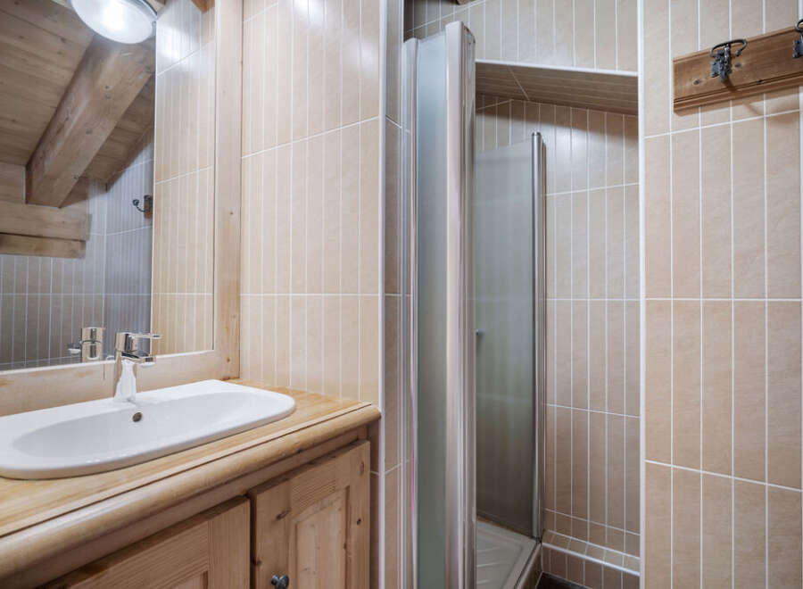 This charming bathroom features a rustic wooden vanity and a sleek, modern sink.