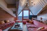Experience the charm of this cozy attic living space, featuring a unique sloped ceiling and exposed wooden beams.