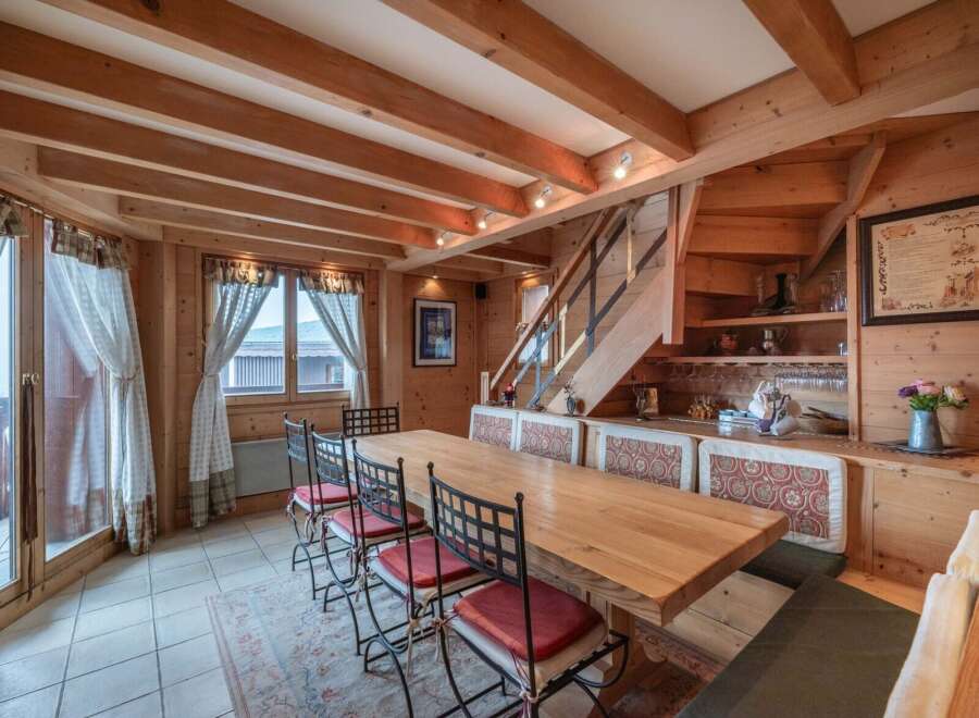 Step into this charming dining area, showcasing a rustic design with exposed wooden beams and paneling.