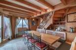 Step into this charming dining area, showcasing a rustic design with exposed wooden beams and paneling.