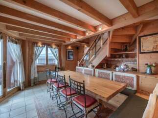Step into this charming dining area, showcasing a rustic design with exposed wooden beams and paneling.