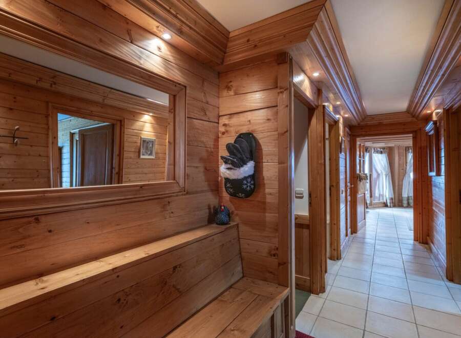 Step into this inviting hallway, showcasing warm wooden paneling and a built-in bench.