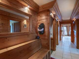 Step into this inviting hallway, showcasing warm wooden paneling and a built-in bench.