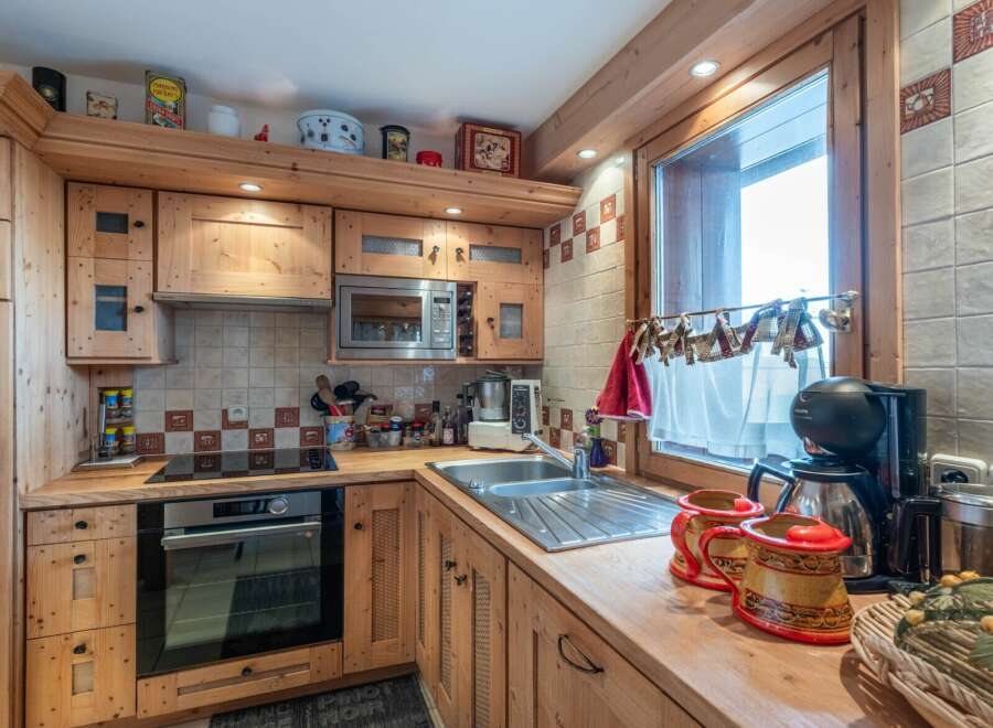 This charming kitchen features custom wooden cabinetry and countertops, creating a warm and inviting atmosphere.