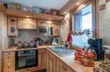 This charming kitchen features custom wooden cabinetry and countertops, creating a warm and inviting atmosphere.