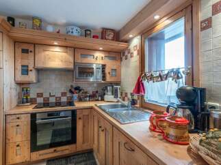 This charming kitchen features custom wooden cabinetry and countertops, creating a warm and inviting atmosphere.