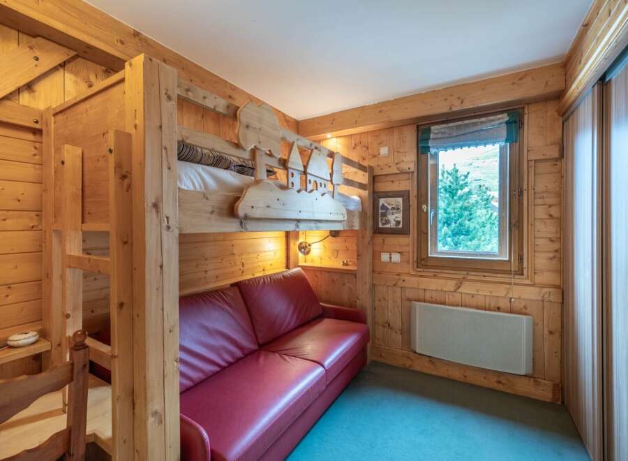This cozy room features a unique bunk bed design with charming wooden accents, perfect for a family getaway.