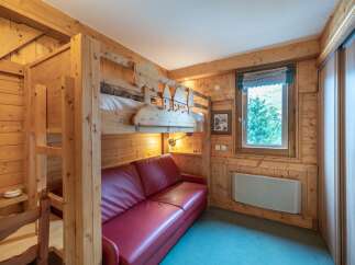 This cozy room features a unique bunk bed design with charming wooden accents, perfect for a family getaway.