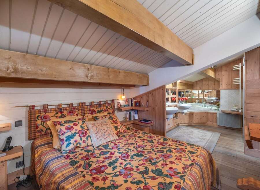This charming bedroom features a cozy bed adorned with a vibrant floral comforter, creating a warm and inviting atmosphere.