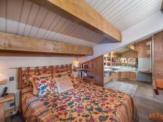 This charming bedroom features a cozy bed adorned with a vibrant floral comforter, creating a warm and inviting atmosphere.