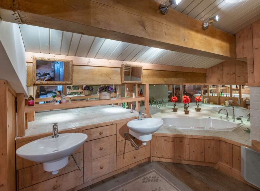 This luxurious bathroom boasts a rustic charm with its wooden accents and elegant design.