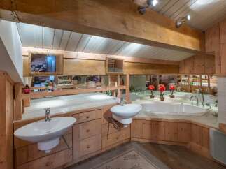 This luxurious bathroom boasts a rustic charm with its wooden accents and elegant design.