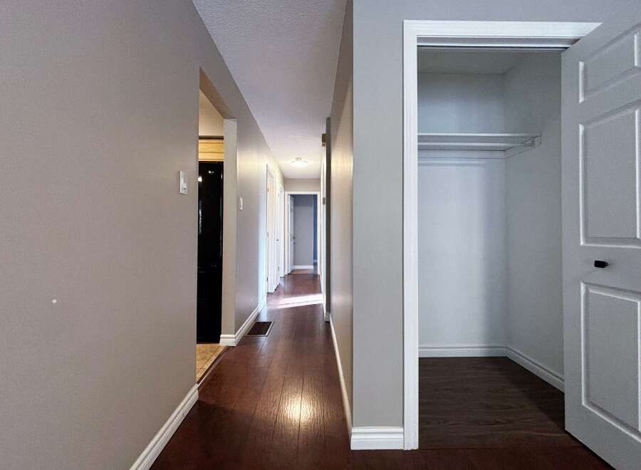 Step into this inviting hallway, showcasing beautiful hardwood floors that extend throughout the space.