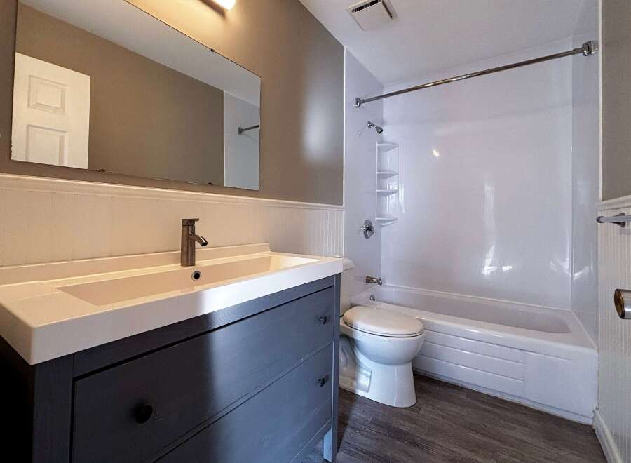 This bathroom features a modern vanity with ample storage and a sleek design.