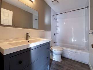 This bathroom features a modern vanity with ample storage and a sleek design.