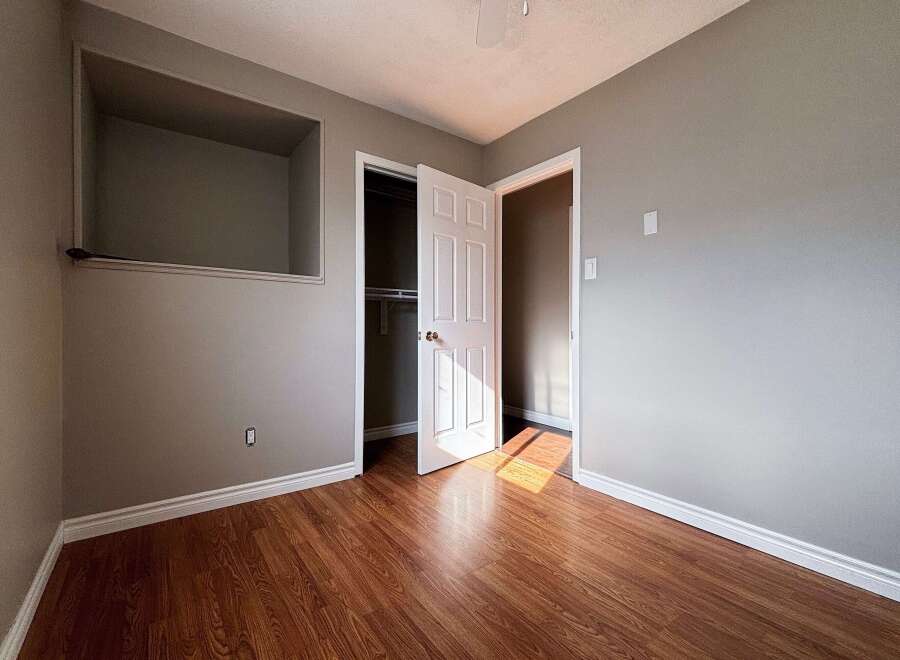 Step into this inviting room featuring warm wood flooring and neutral walls, creating a versatile space ready for your personal touch.
