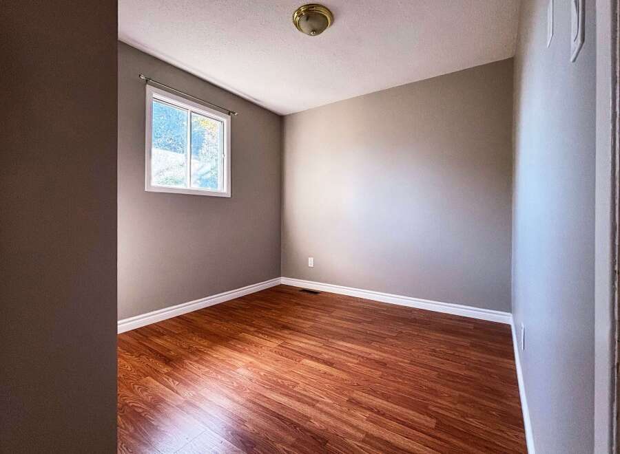 This inviting room features a warm, inviting atmosphere with its rich, wood-look flooring and neutral wall colors.