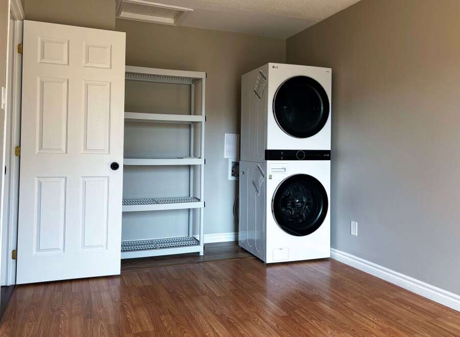 This laundry room features a modern stacked washer and dryer, perfect for maximizing space.