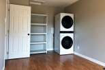 This laundry room features a modern stacked washer and dryer, perfect for maximizing space.