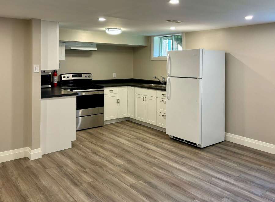 This kitchen features a modern design with sleek white cabinetry and a stainless steel oven.