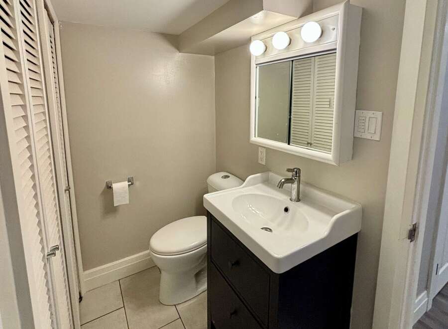 This charming bathroom features a stylish vanity with a sleek sink and ample storage.