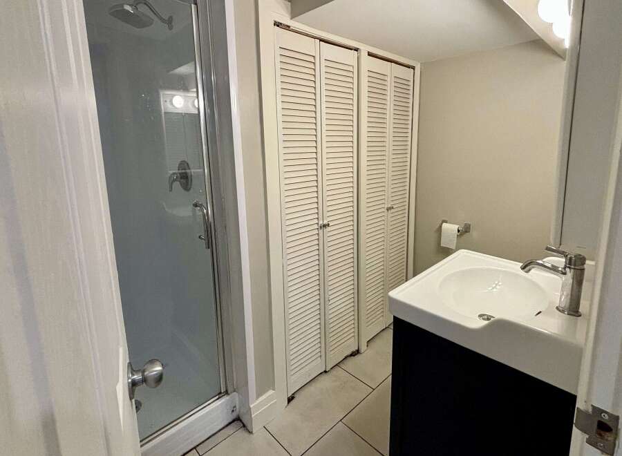 This bathroom features a modern design with a sleek shower enclosure and a stylish vanity.