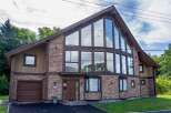 This stunning property boasts a unique architectural design with a striking A-frame structure and expansive windows that flood the interior with natural light.