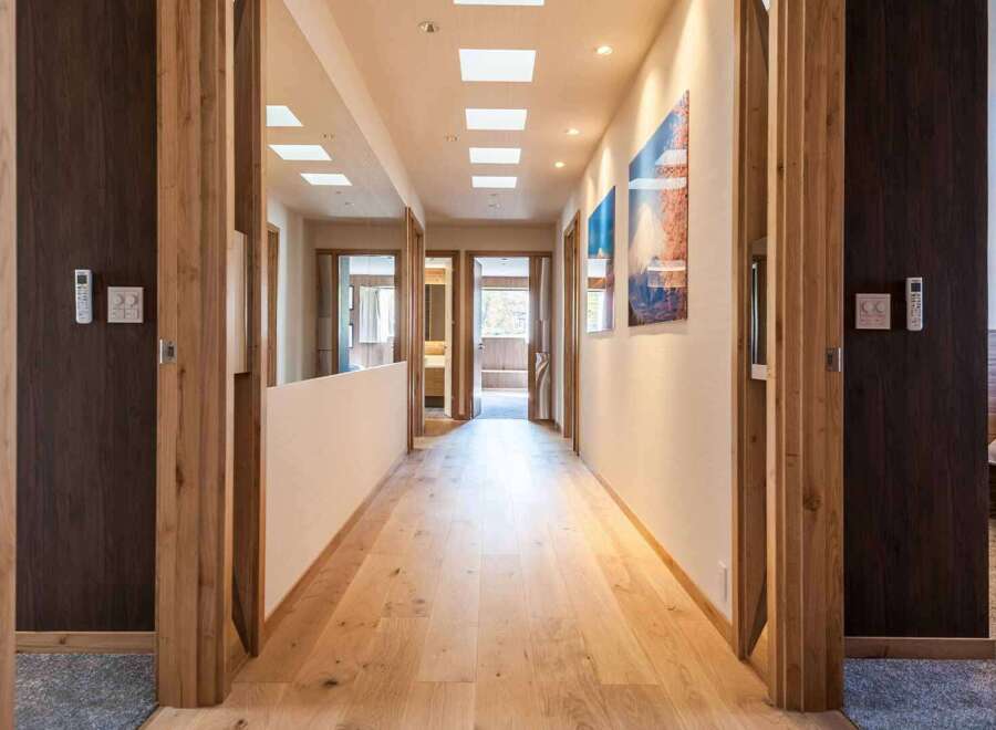 Step into luxury with this stunning hallway, showcasing exquisite wooden flooring and elegant door frames.