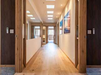 Step into luxury with this stunning hallway, showcasing exquisite wooden flooring and elegant door frames.