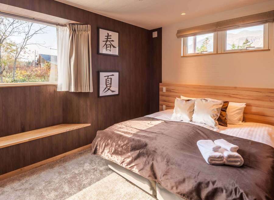 Experience tranquility in this cozy bedroom featuring a warm wooden headboard and accents.