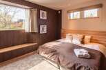 Experience tranquility in this cozy bedroom featuring a warm wooden headboard and accents.