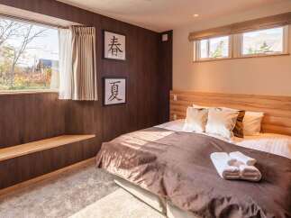 Experience tranquility in this cozy bedroom featuring a warm wooden headboard and accents.