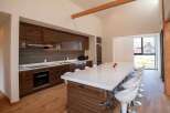 This modern kitchen boasts sleek, dark wood cabinetry and a spacious island with seating, perfect for entertaining.