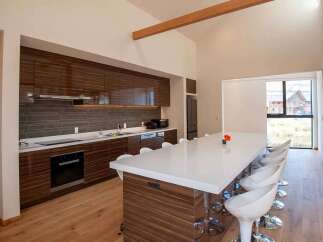 This modern kitchen boasts sleek, dark wood cabinetry and a spacious island with seating, perfect for entertaining.