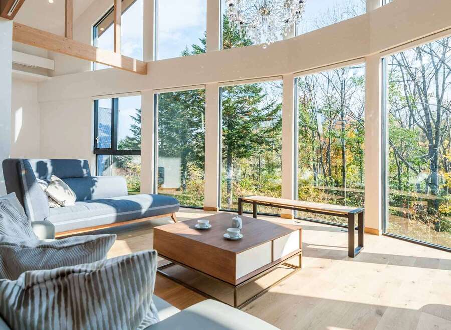 Experience luxury living in this stunning property, featuring expansive windows that flood the space with natural light and offer breathtaking views of the surrounding forest.