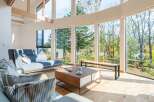 Experience luxury living in this stunning property, featuring expansive windows that flood the space with natural light and offer breathtaking views of the surrounding forest.