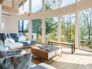 Experience luxury living in this stunning property, featuring expansive windows that flood the space with natural light and offer breathtaking views of the surrounding forest.