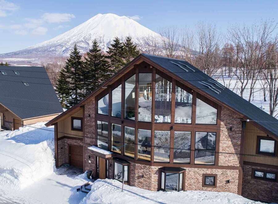 This stunning property boasts a modern design with expansive windows offering breathtaking views of the snow-capped mountain.
