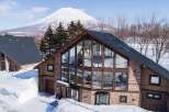 This stunning property boasts a modern design with expansive windows offering breathtaking views of the snow-capped mountain.