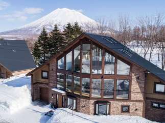 This stunning property boasts a modern design with expansive windows offering breathtaking views of the snow-capped mountain.