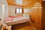 Discover this charming bedroom featuring a cozy wooden ceiling and walls, creating a warm and inviting atmosphere.