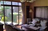 This charming property boasts a bright and airy living room with a stunning view of a meticulously landscaped garden.