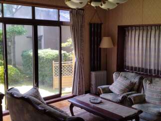 This charming property boasts a bright and airy living room with a stunning view of a meticulously landscaped garden.