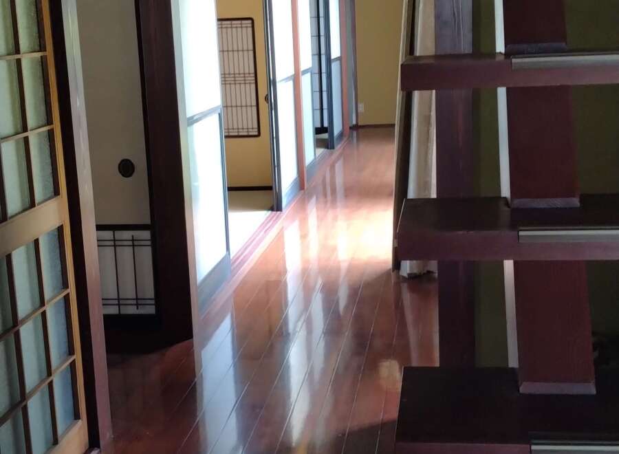 Step into this stunning Japanese-inspired home, featuring a beautiful wooden staircase and a bright, open hallway.